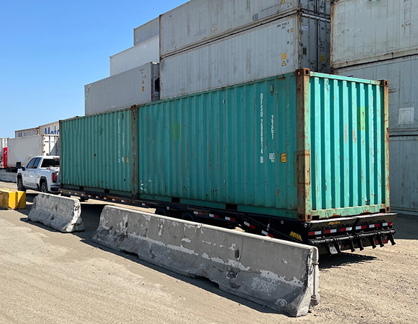 Two Green 20 Foot Cargo Worthy Shipping Containers on Truck