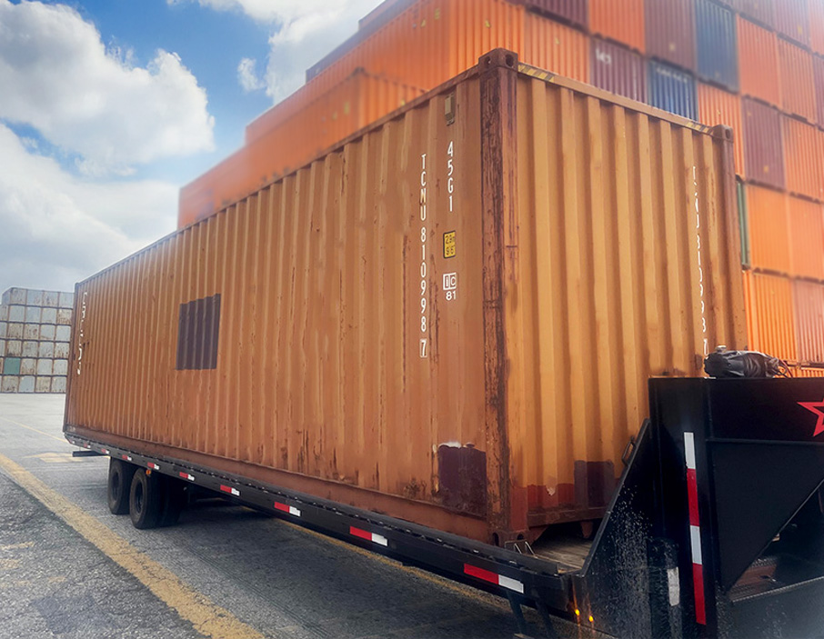 a single shipping container still on the transportation bed, ready for unloading