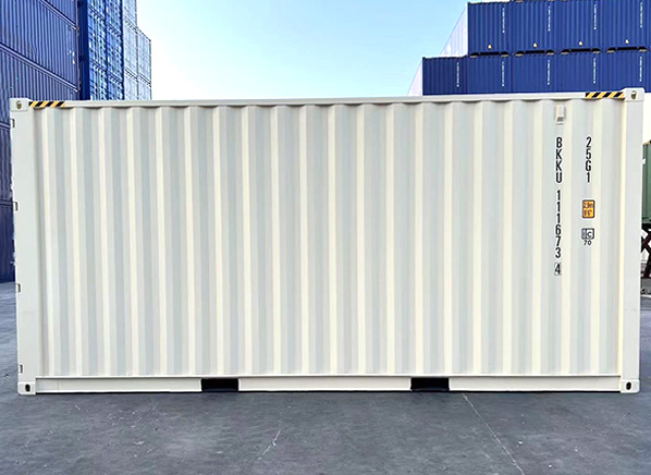 a side photo of a single white shipping container, with several stacked blue containers in the background